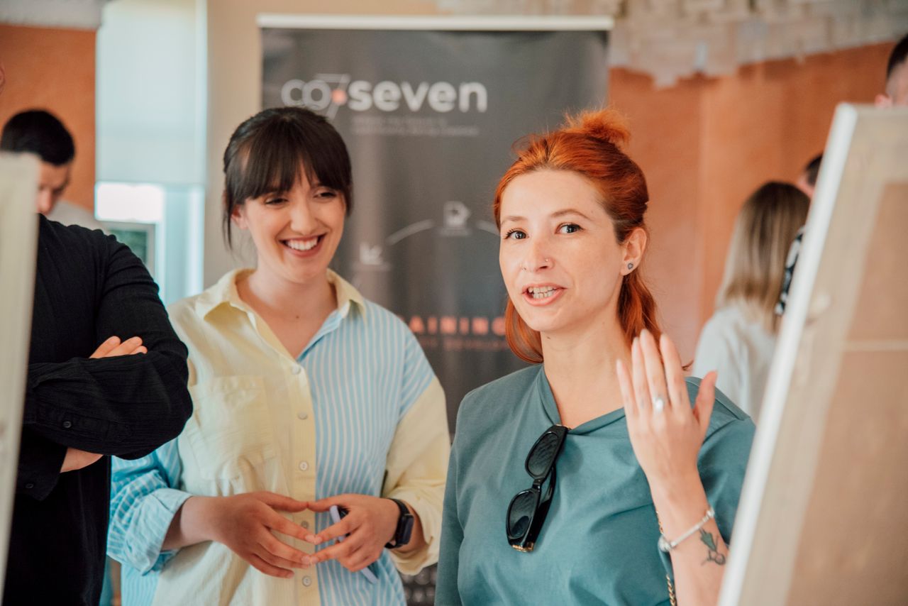 Two women engaging in a lively discussion during a workshop session indoors.