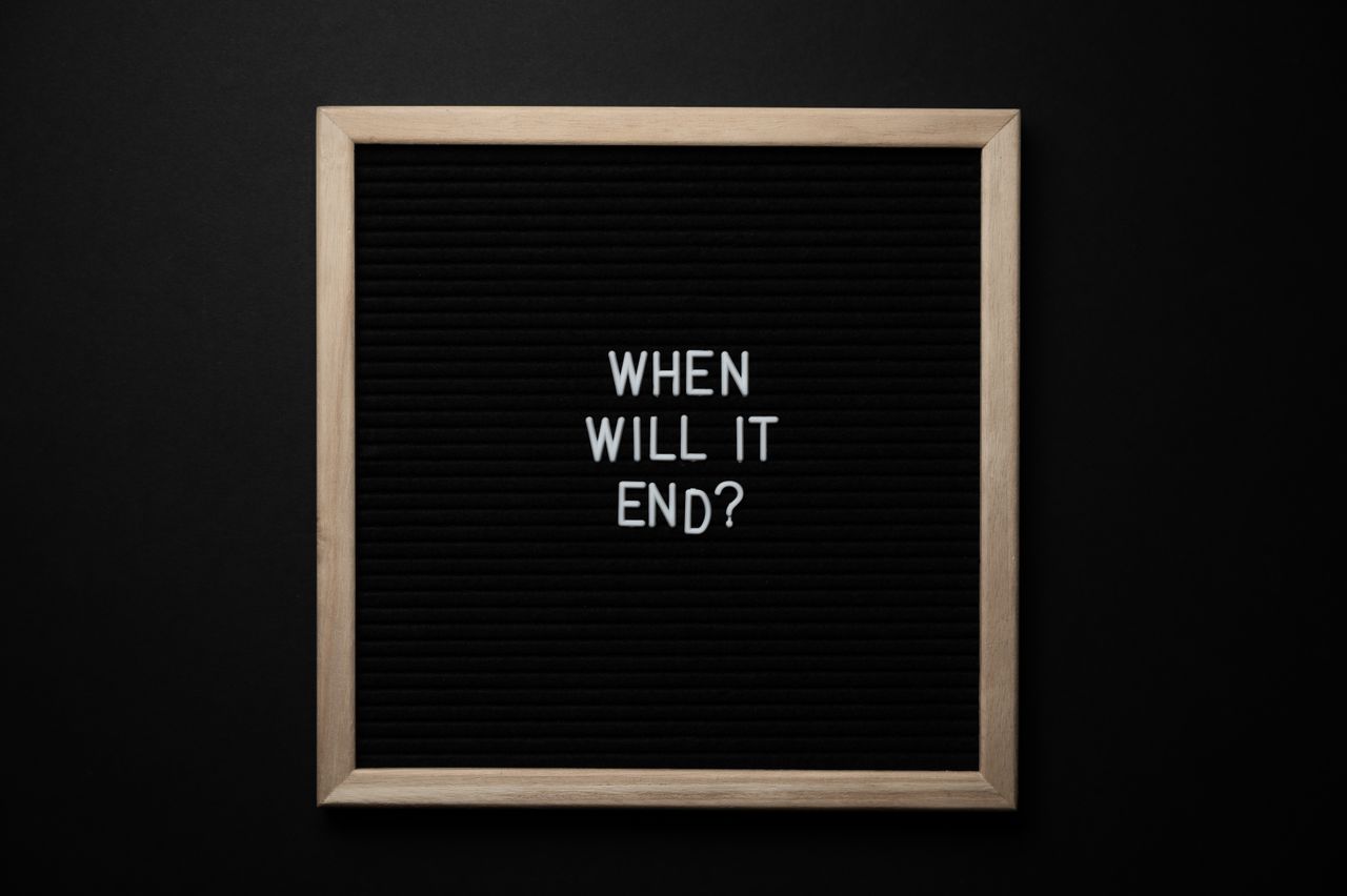 From above of chalkboard with When Will It End inscription on black background