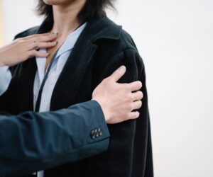 Detailed close-up image showing a person in a black blazer with hands gesturing on chest. Great for business and lifestyle themes.